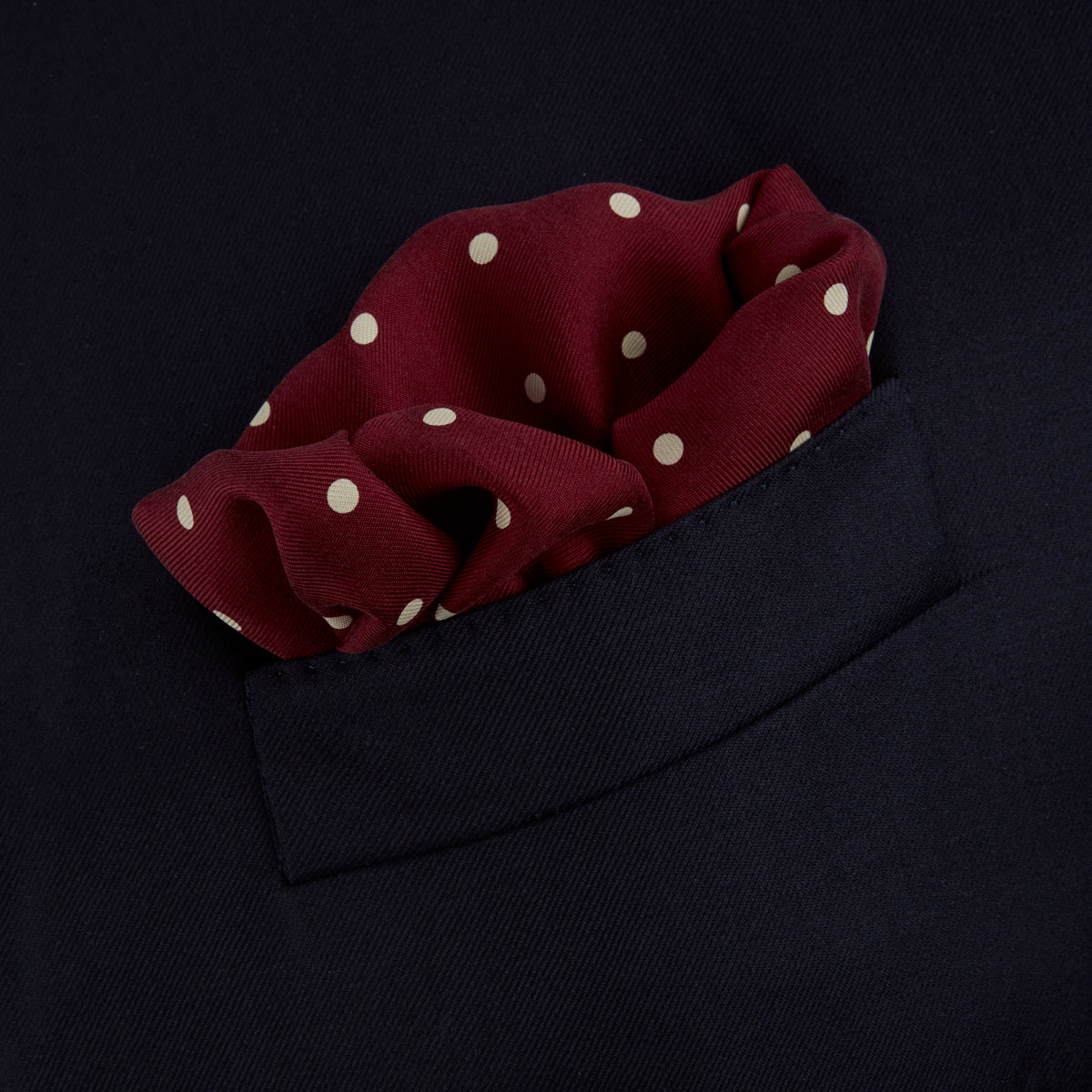 View 4 of product Add a touch of elegance with the Turnbull & Asser Burgundy Spot Silk Pocket Square, featuring white dots, a printed corner logo, and folded edging—a classic men’s accessory for any occasion.