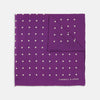 View 1 of product The Turnbull & Asser Purple Spot Silk Pocket Square features white polka dots and a small logo in the corner, with one corner folded over to showcase the underside.
