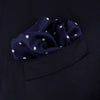 View 4 of product The Navy Spot Silk Pocket Square by Turnbull & Asser features a white polka dot pattern and is neatly folded at one corner, with the brand name printed in white on the lower right—perfect for pairing with pinstripe suits.