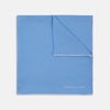 View 1 of product A Blue and White Piped Silk Pocket Square by Turnbull & Asser, neatly folded with the brand name in white on the lower right corner, displayed against a plain white background.