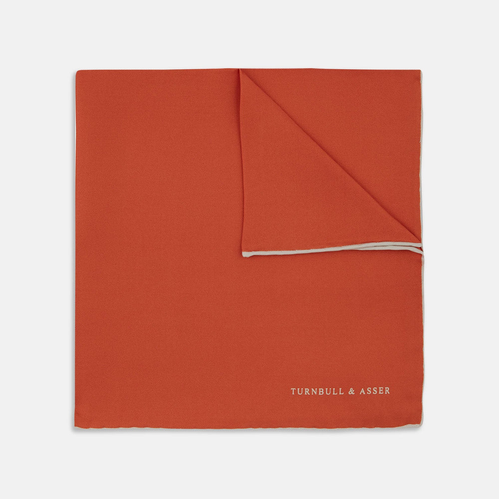 A classic men's accessory, the Turnbull & Asser Dark Orange and White Piped Silk Pocket Square adds a timeless touch to any look.