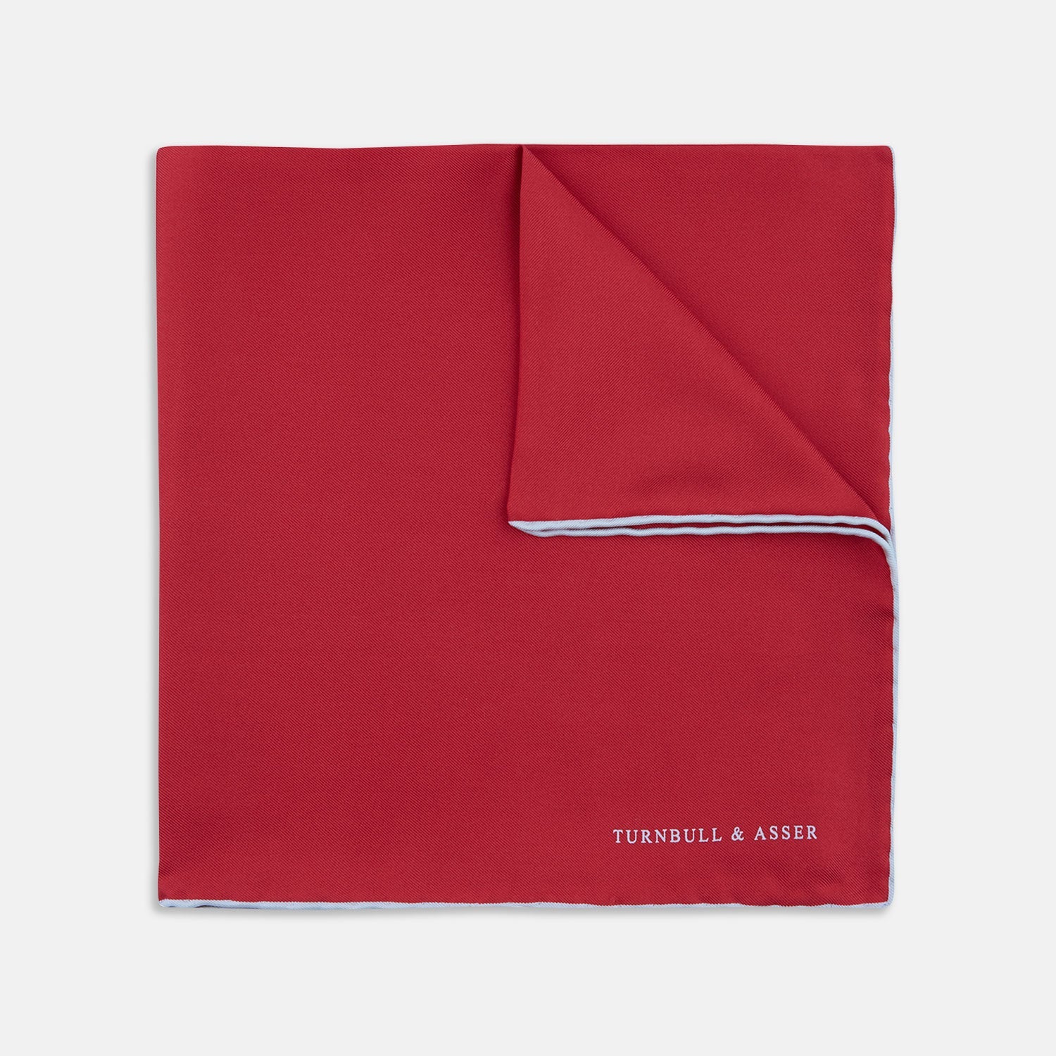 View 1 of product A classic accessory, the Turnbull & Asser Red and White Piped Silk Pocket Square is neatly folded to showcase both colors, with the brand’s logo in white on the corner.