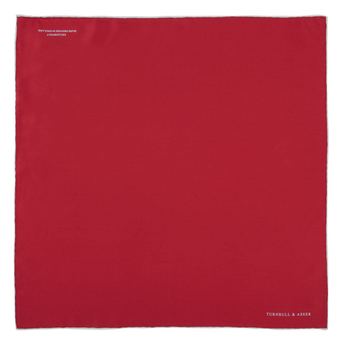 View 2 of product A classic accessory, the Turnbull & Asser Red and White Piped Silk Pocket Square is neatly folded to showcase both colors, with the brand’s logo in white on the corner.