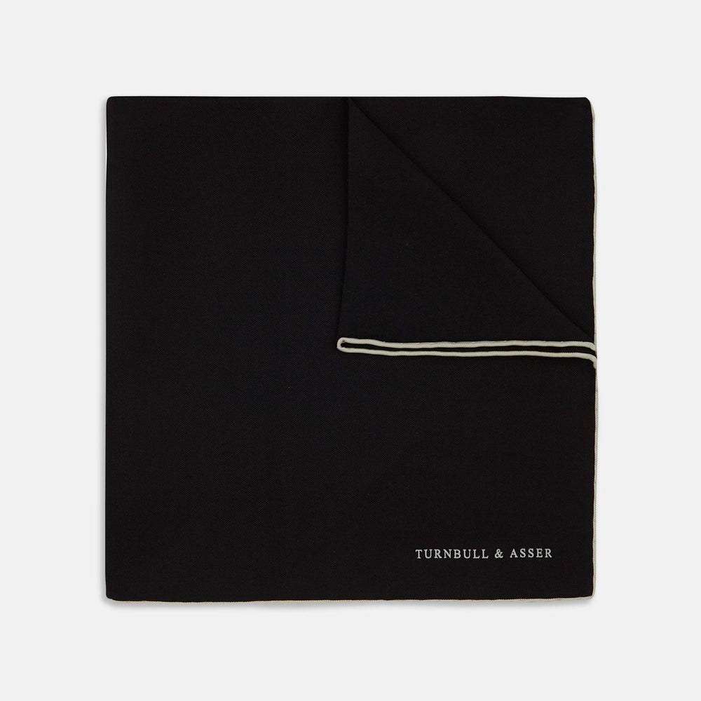 Add a touch of elegance with Turnbull & Asser’s Black and White Piped Silk Pocket Square, featuring white piping on one edge and the brand’s embroidered logo in white for a refined, classic look.