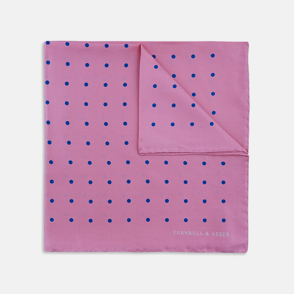 The Turnbull & Asser Rose and Blue Spot Silk Pocket Square features a pastel pink base with evenly spaced blue spots and a discreet white logo in one corner, finished with a slightly folded top for added flair.