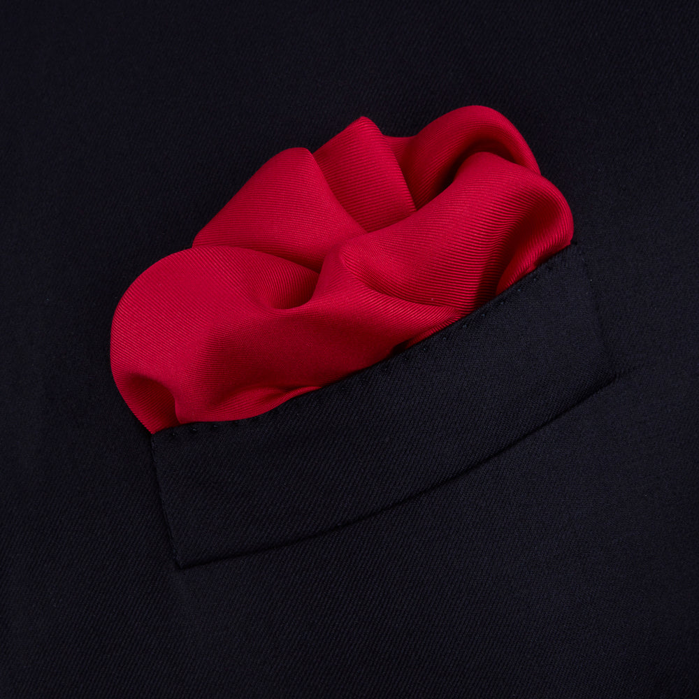 The Red and Navy Piped Silk Pocket Square by Turnbull & Asser features classic red silk with navy edging and the brand’s name printed in white on the bottom right corner.