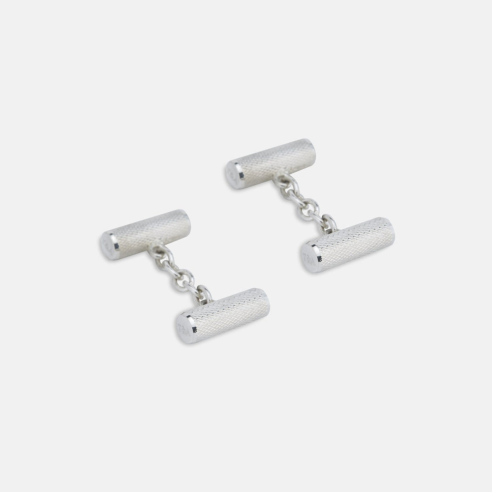Turnbull & Asser’s Sterling Silver Bar Cufflinks feature a textured cylindrical design and chain links, making them an elegant men’s accessory, shown here on a plain white background.