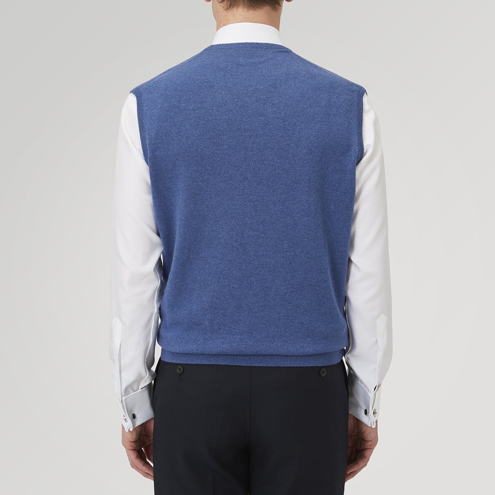 View 3 of product The Turnbull & Asser Blue V-Neck Cashmere Slipover, neatly folded with the label visible, is crafted from soft cashmere and ideal for formal layering. Shown against a white background.