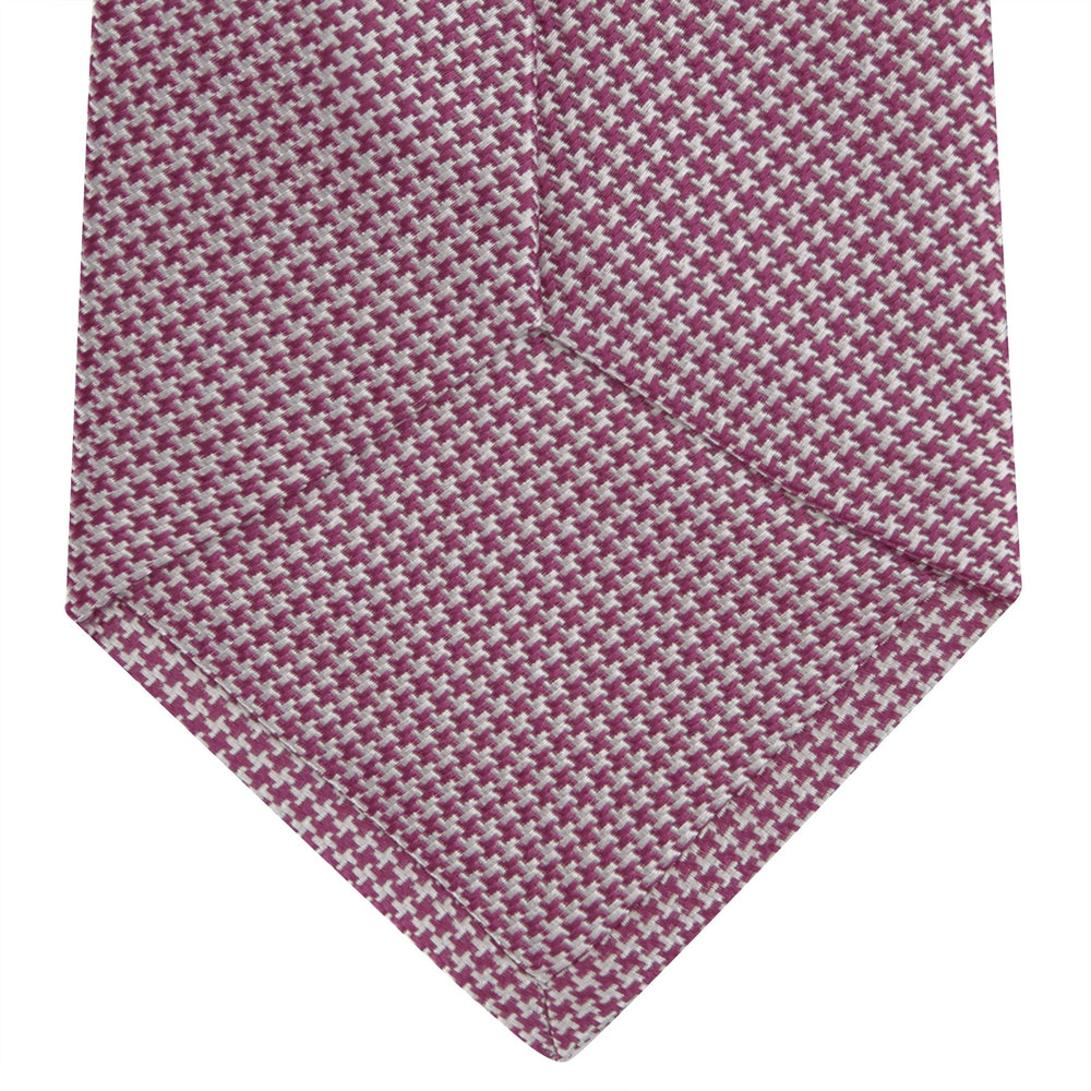 The Turnbull & Asser Dark Pink Houndstooth Silk Tie is rolled up and displayed on a plain white background.