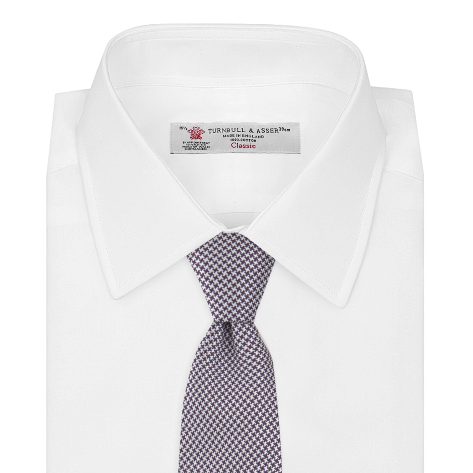 View 2 of product The Plum Houndstooth Silk Tie by Turnbull & Asser features a refined small black, white, and gray pattern—perfect as an office shirt accessory—shown rolled up on a plain white background.