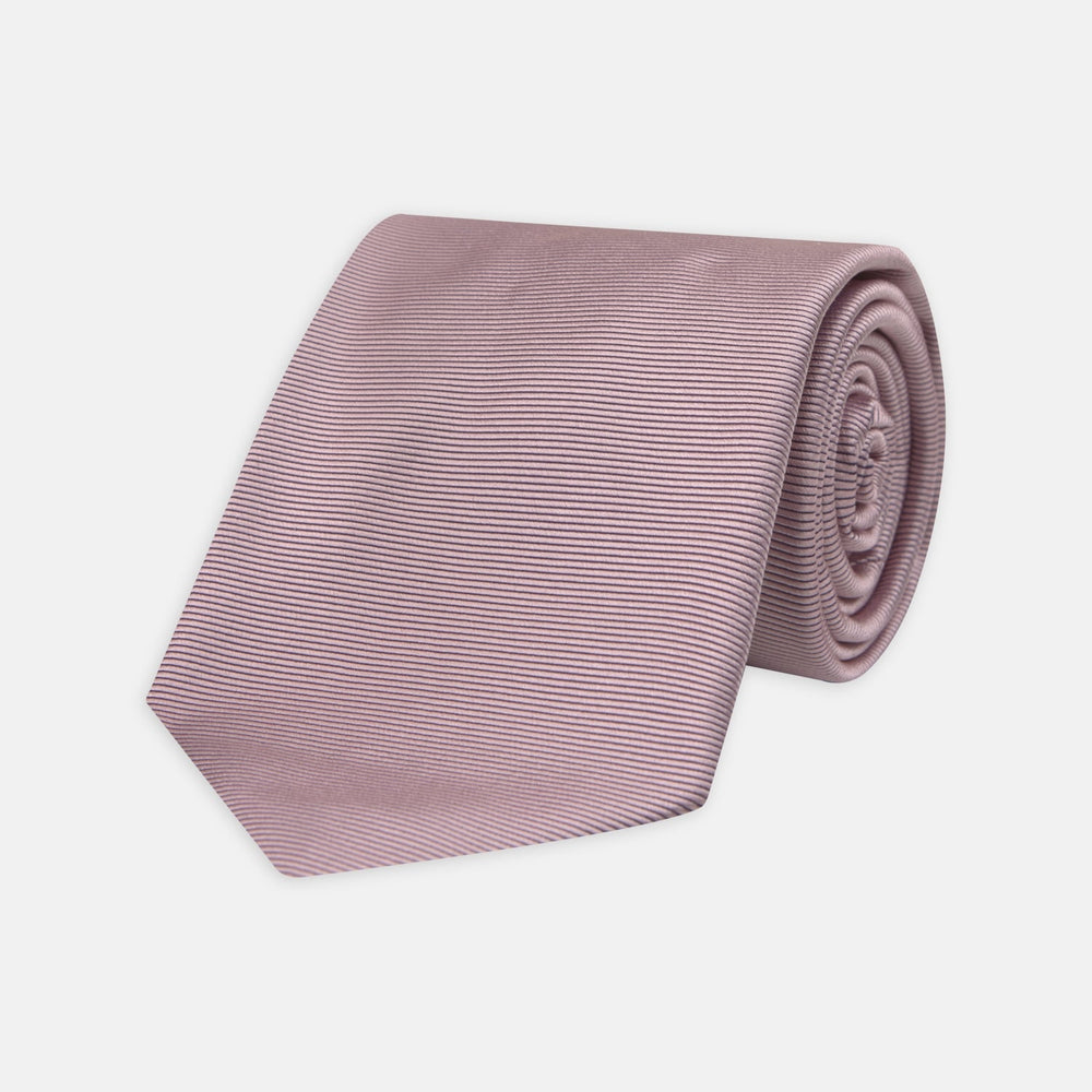 The Turnbull & Asser Rose Horizontal Twill Silk Tie features a pale pink ribbed silk texture, displayed on a white background—ideal for adding a smart touch to cotton shirts.
