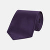 View 1 of product The Turnbull & Asser Plum Plain Satin Silk Tie, shown rolled up on a white background, highlights its classic and versatile style for any occasion.