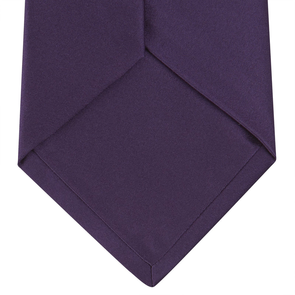 The Turnbull & Asser Plum Plain Satin Silk Tie, shown rolled up on a white background, highlights its classic and versatile style for any occasion.
