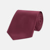 View 1 of product A Turnbull & Asser Dark Pink Plain Satin Silk Tie, crafted from satin silk, is rolled up and displayed on a plain white background.