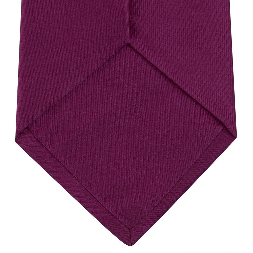 A Turnbull & Asser Dark Pink Plain Satin Silk Tie, crafted from satin silk, is rolled up and displayed on a plain white background.