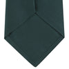 View 4 of product The Turnbull & Asser Forest Green Plain Satin Silk Tie, neatly rolled with a pointed end, is displayed on a plain white background.