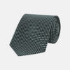 View 1 of product The Turnbull & Asser Forest Green and White Diamond Silk Tie features a geometric pattern of small, evenly spaced white diamonds on a forest green background, displayed rolled up on a white surface.