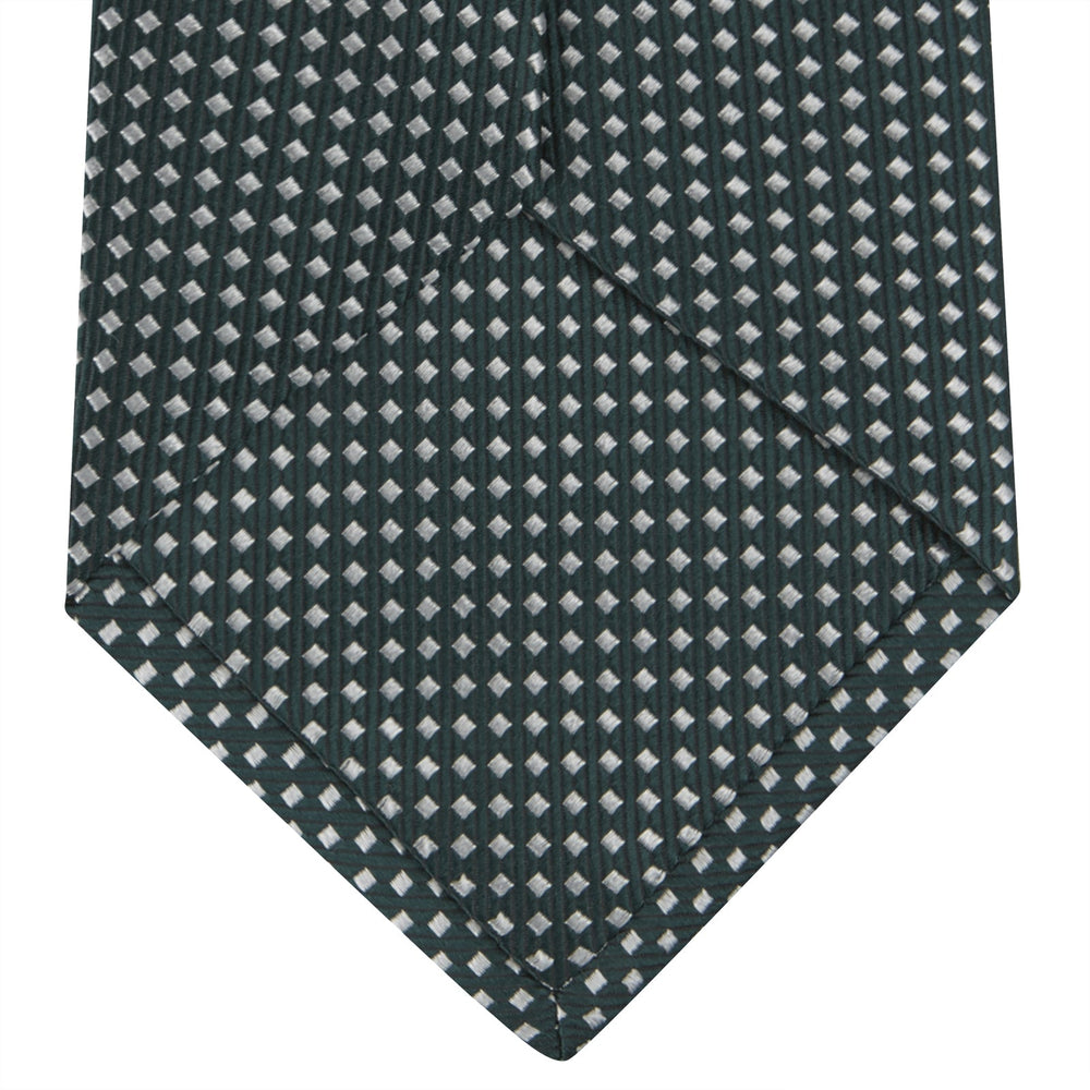 The Turnbull & Asser Forest Green and White Diamond Silk Tie features a geometric pattern of small, evenly spaced white diamonds on a forest green background, displayed rolled up on a white surface.