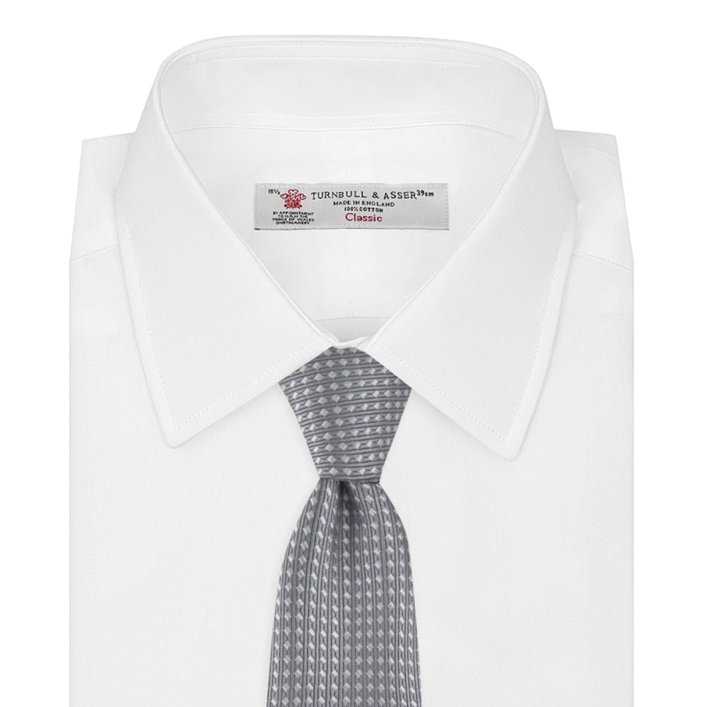 The Turnbull & Asser Grey and White Diamond Silk Tie, featuring a subtle textured pattern, is perfect for pairing with an office shirt and is displayed against a white background.