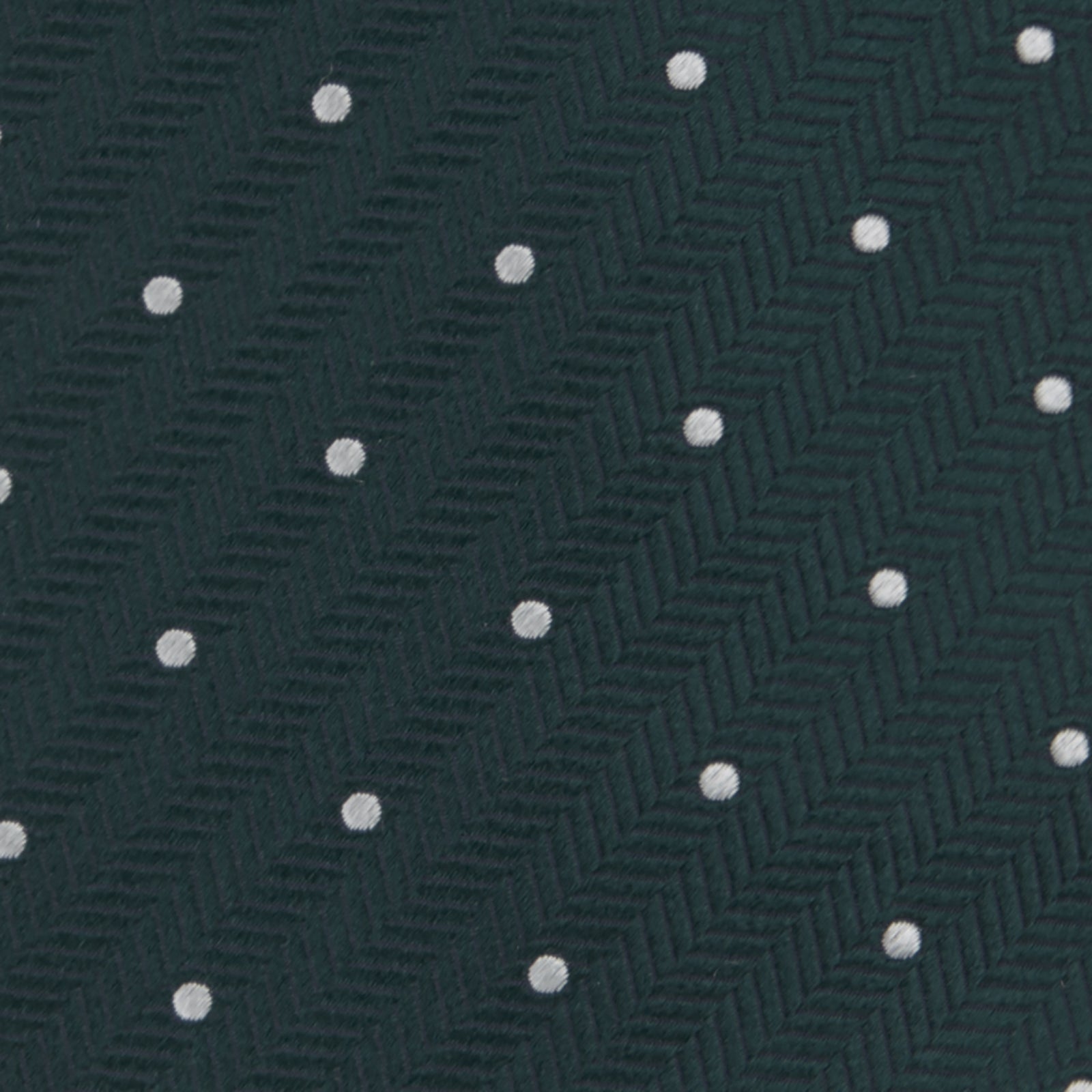 View 3 of product The Forest Green and White Small Spot Herringbone Silk Tie by Turnbull & Asser features a dark green woven herringbone pattern with small white spots, crafted from fine English silk and shown rolled up on a white background.