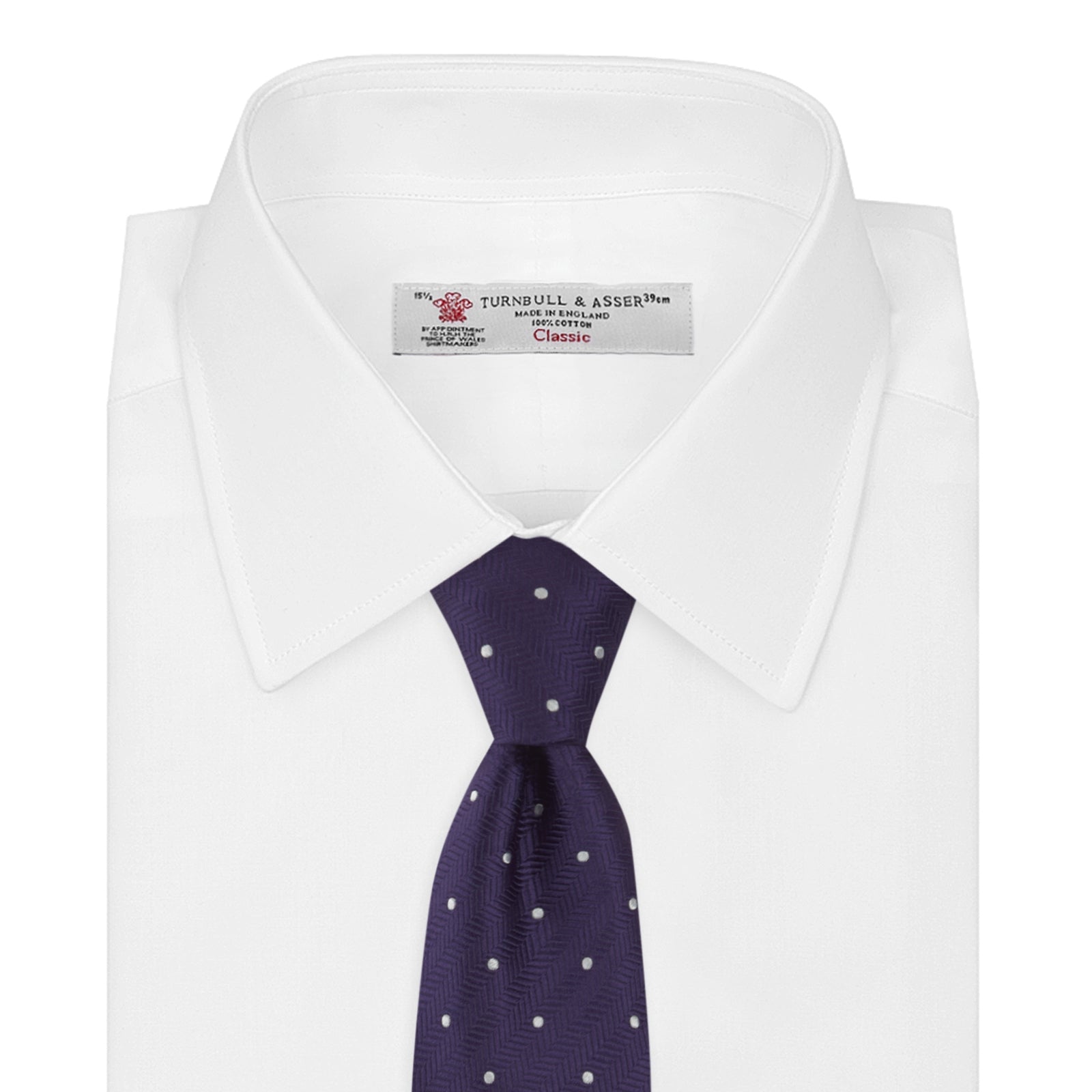 View 2 of product The Turnbull & Asser Plum and White Small Spot Herringbone Silk Tie is shown rolled up on a plain white background, featuring a classic silk herringbone weave in plum with small white spots.