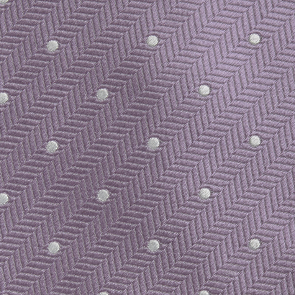 The Turnbull & Asser Lilac and White Small Spot Herringbone Silk Tie, crafted from fine English silk, is neatly rolled and displayed on a plain white background.