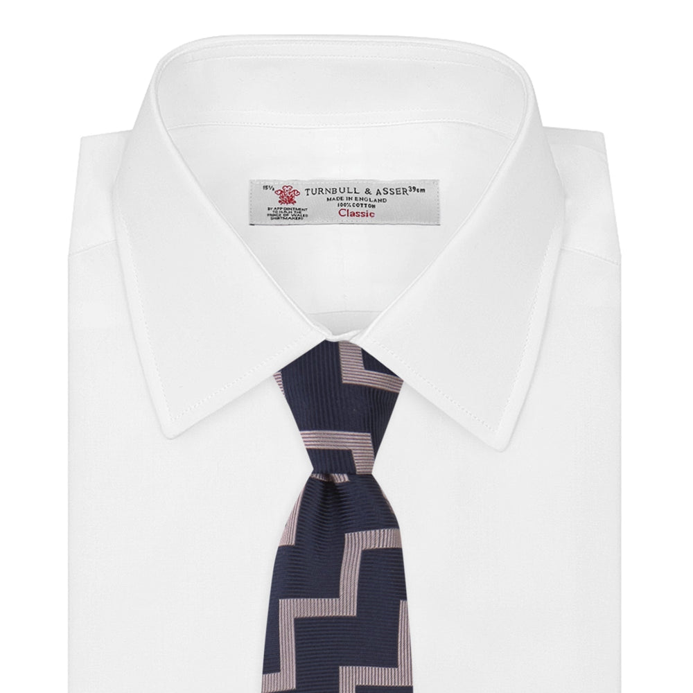 The Turnbull & Asser Navy and Rose Striped Zigzag Silk Tie features a bold zigzag pattern and is shown against a plain white background, making it an ideal accessory for the modern gentleman.