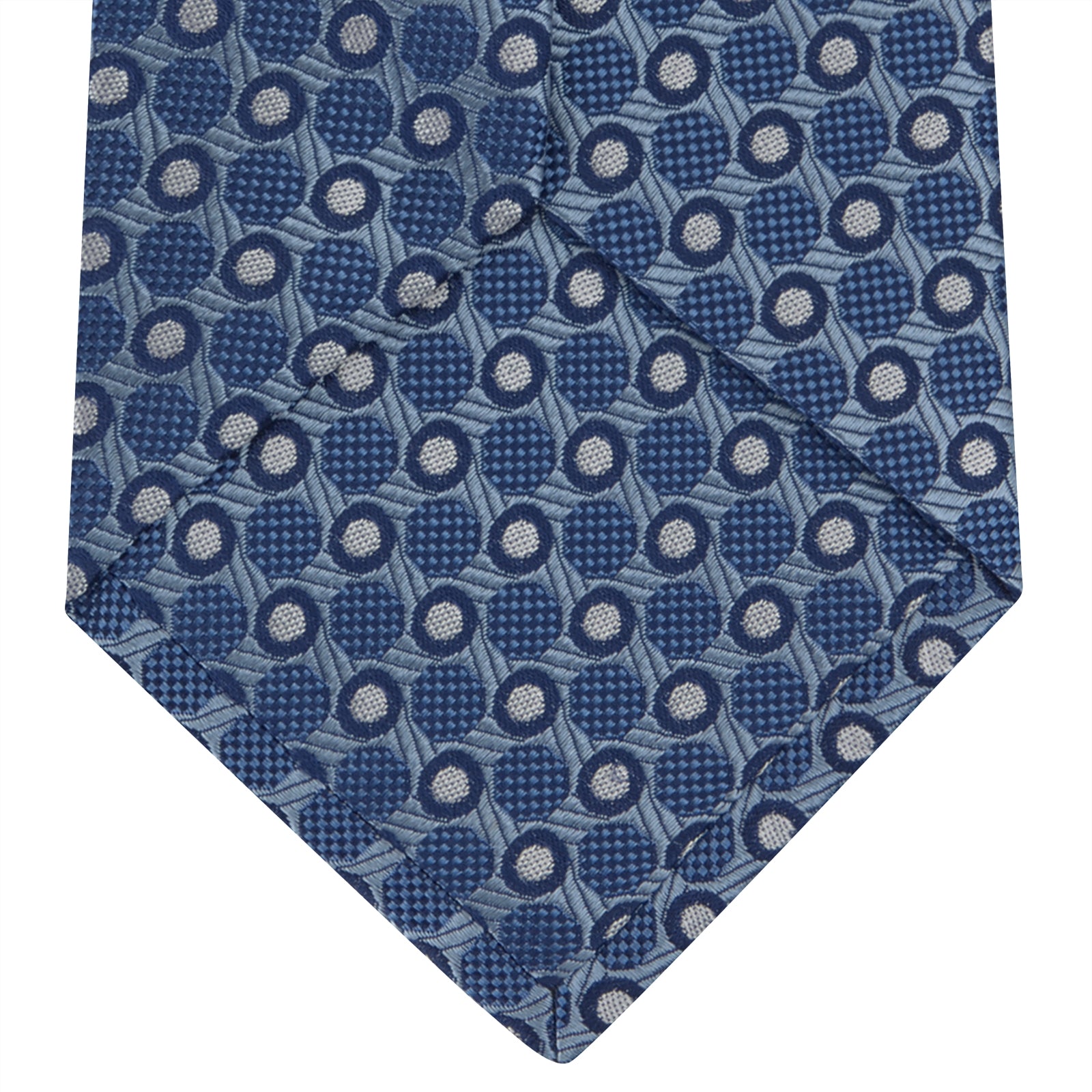 View 4 of product The Turnbull & Asser Blue Circle and Spot Silk Tie features a refined pattern of light blue and silver circles—ideal for pairing with an office shirt, elegantly displayed rolled on a plain white background.