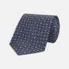 View 1 of product The Turnbull & Asser Brown and Blue Circle and Spot Silk Tie features a repeating pattern of brown and blue spots, ideal for office wear, shown on a white background.