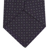 View 4 of product The Turnbull & Asser Plum Floral Spot Silk Tie features a rolled-up classic design with small, evenly spaced floral spots in lighter purple and white, ideal for office shirts and shown against a plain white background.