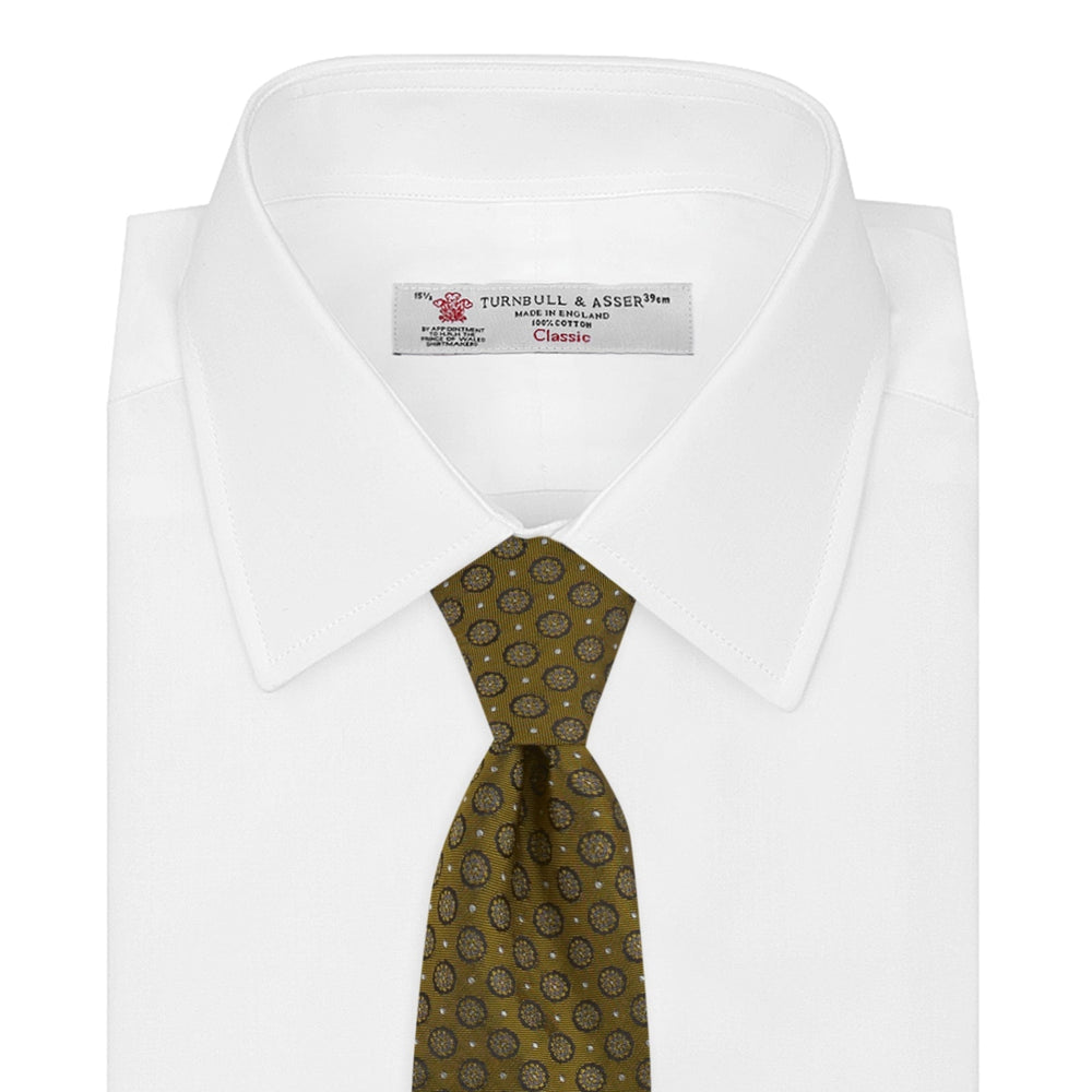 The Gold Floral Spot Silk Tie by Turnbull & Asser showcases a rolled-up design in olive green silk with light floral spots, perfect for adding a refined touch to any office shirt and standing out against a plain white background.