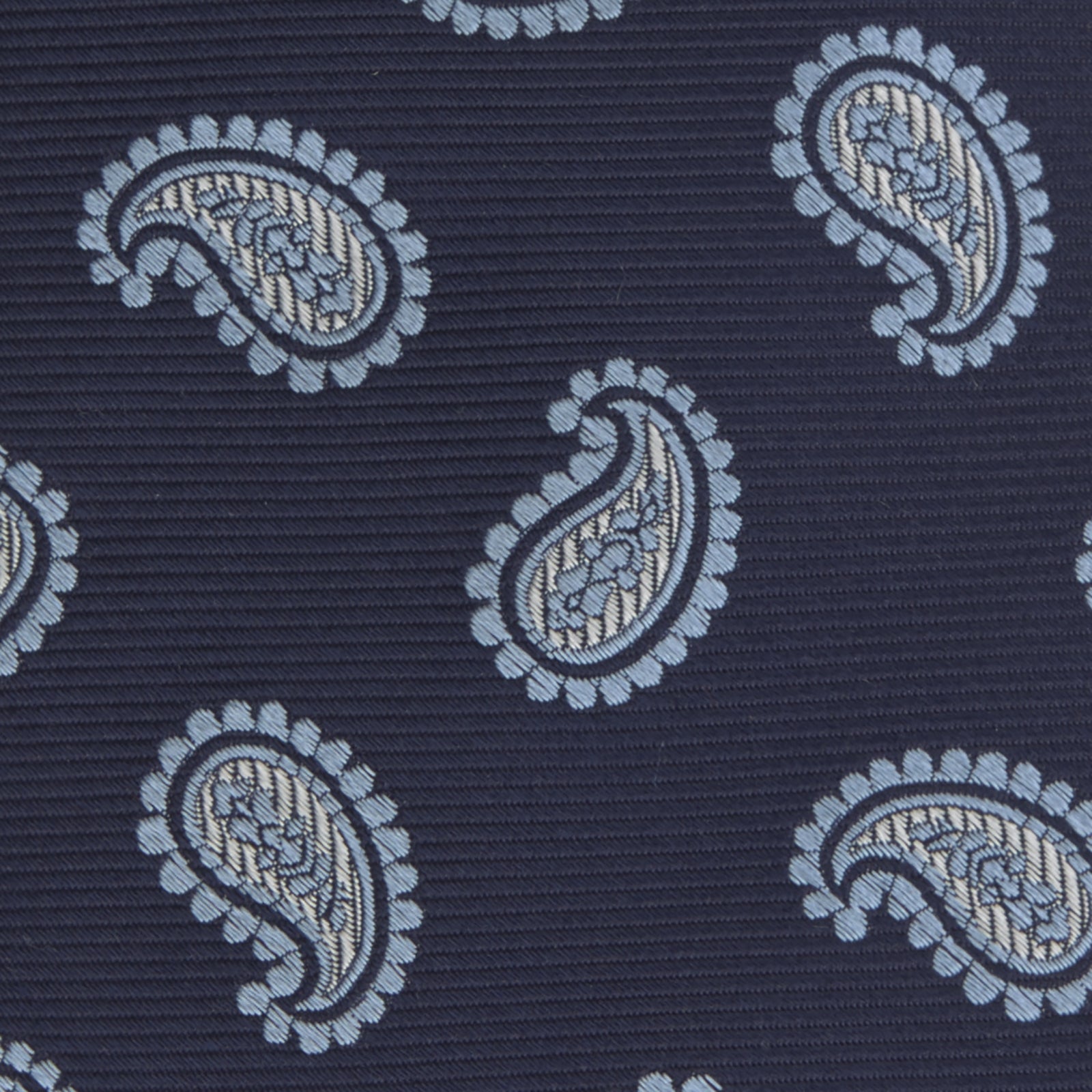 View 3 of product The Turnbull & Asser Navy and Light Blue Floating Paisley Silk Tie features a repeating light blue and white paisley pattern set against a navy blue silk backdrop.