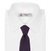 View 2 of product The Turnbull & Asser Navy and Red Paint Spot Silk Tie, featuring red spots on navy blue silk, is rolled with the wide end forward—ideal for office shirts and shown against a white background.