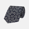 View 1 of product The Turnbull & Asser Navy and White Petal Paisley Silk Tie, featuring an elegant abstract pattern, is neatly rolled against a plain white background.