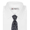 View 2 of product The Turnbull & Asser Navy and White Petal Paisley Silk Tie, featuring an elegant abstract pattern, is neatly rolled against a plain white background.