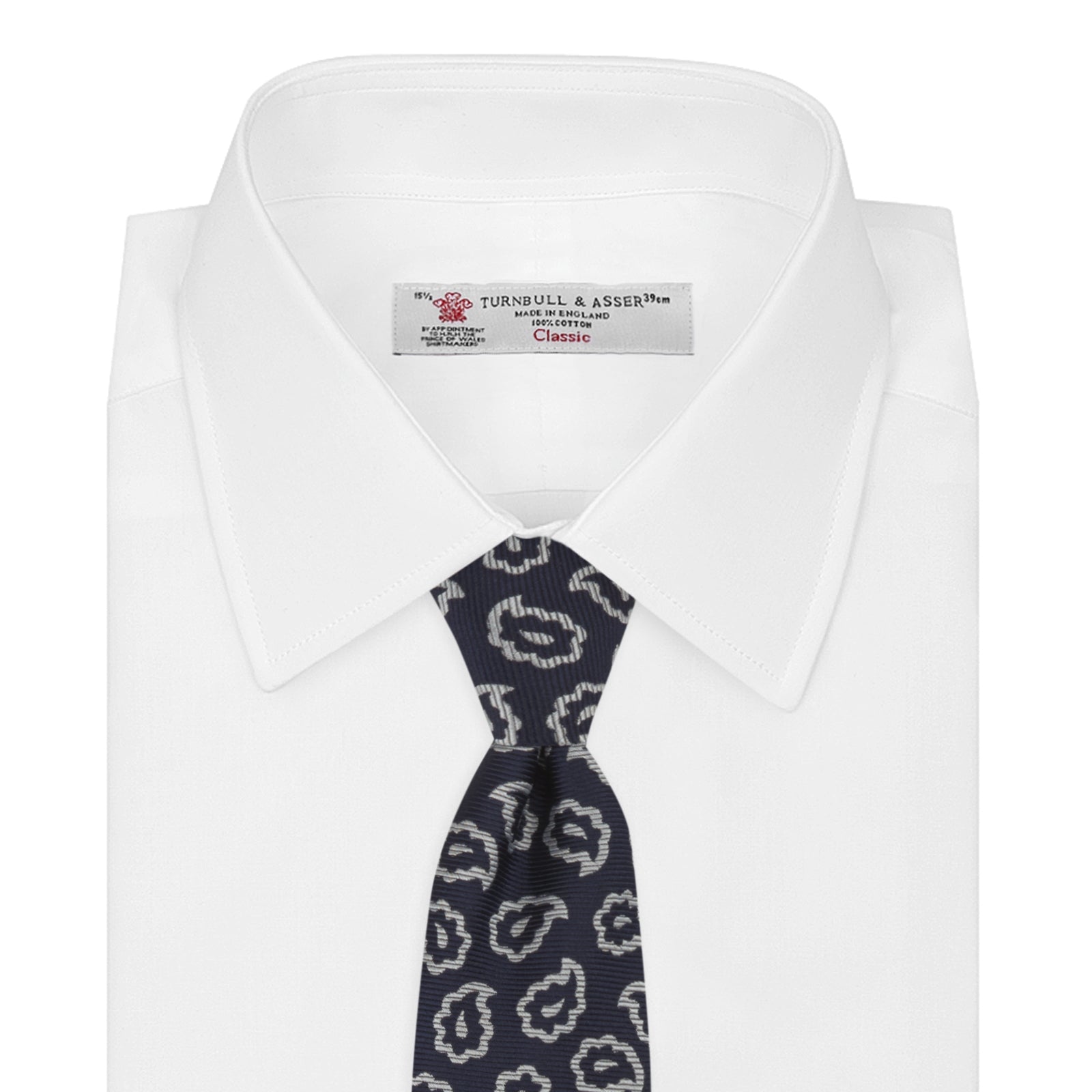 View 2 of product The Turnbull & Asser Navy and White Petal Paisley Silk Tie, featuring an elegant abstract pattern, is neatly rolled against a plain white background.