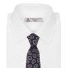 View 2 of product The Turnbull & Asser Navy and Pink Petal Paisley Silk Tie features a repeating petal paisley pattern in pink, shown rolled with the pointed end forward against a plain white background.