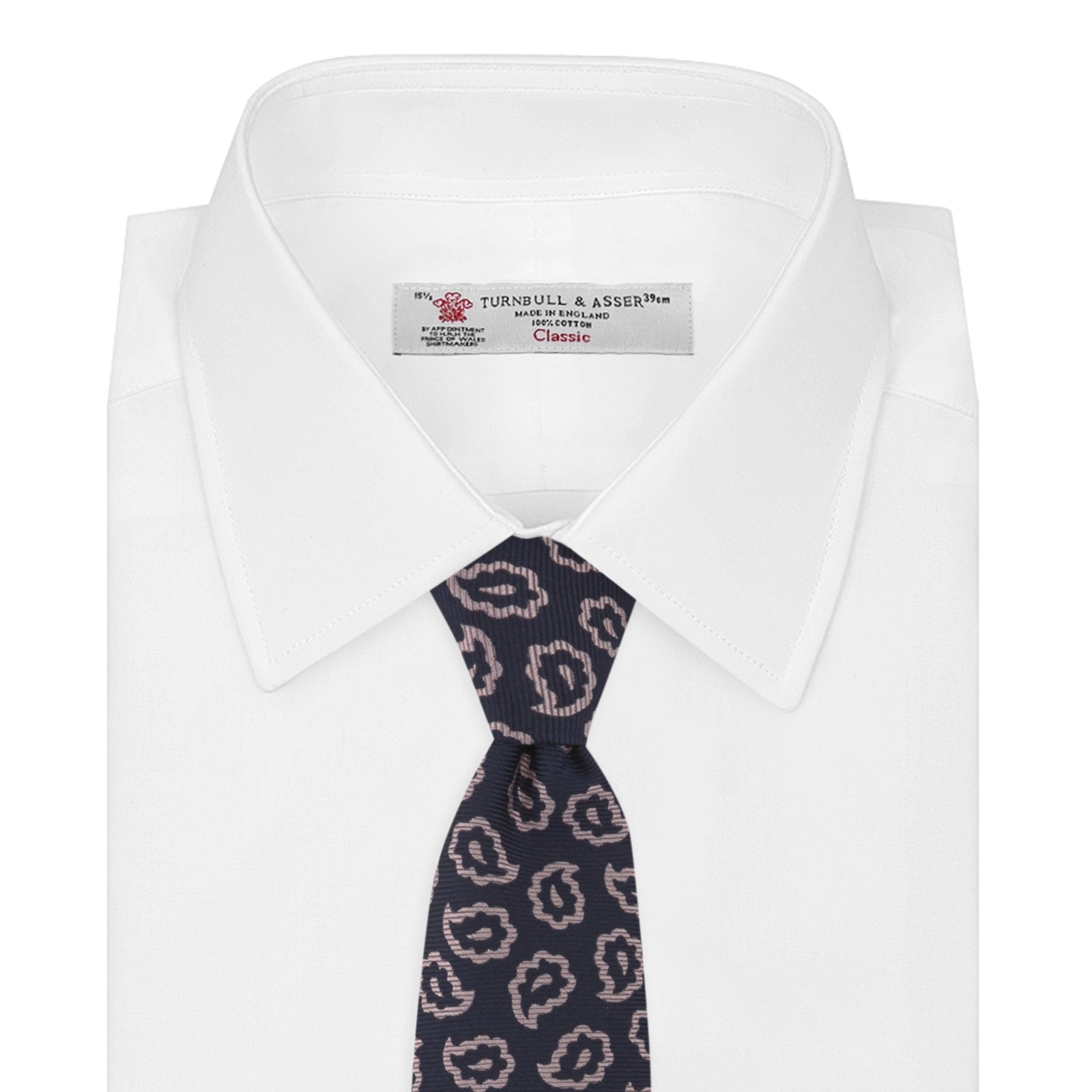 View 2 of product The Turnbull & Asser Navy and Pink Petal Paisley Silk Tie features a repeating petal paisley pattern in pink, shown rolled with the pointed end forward against a plain white background.