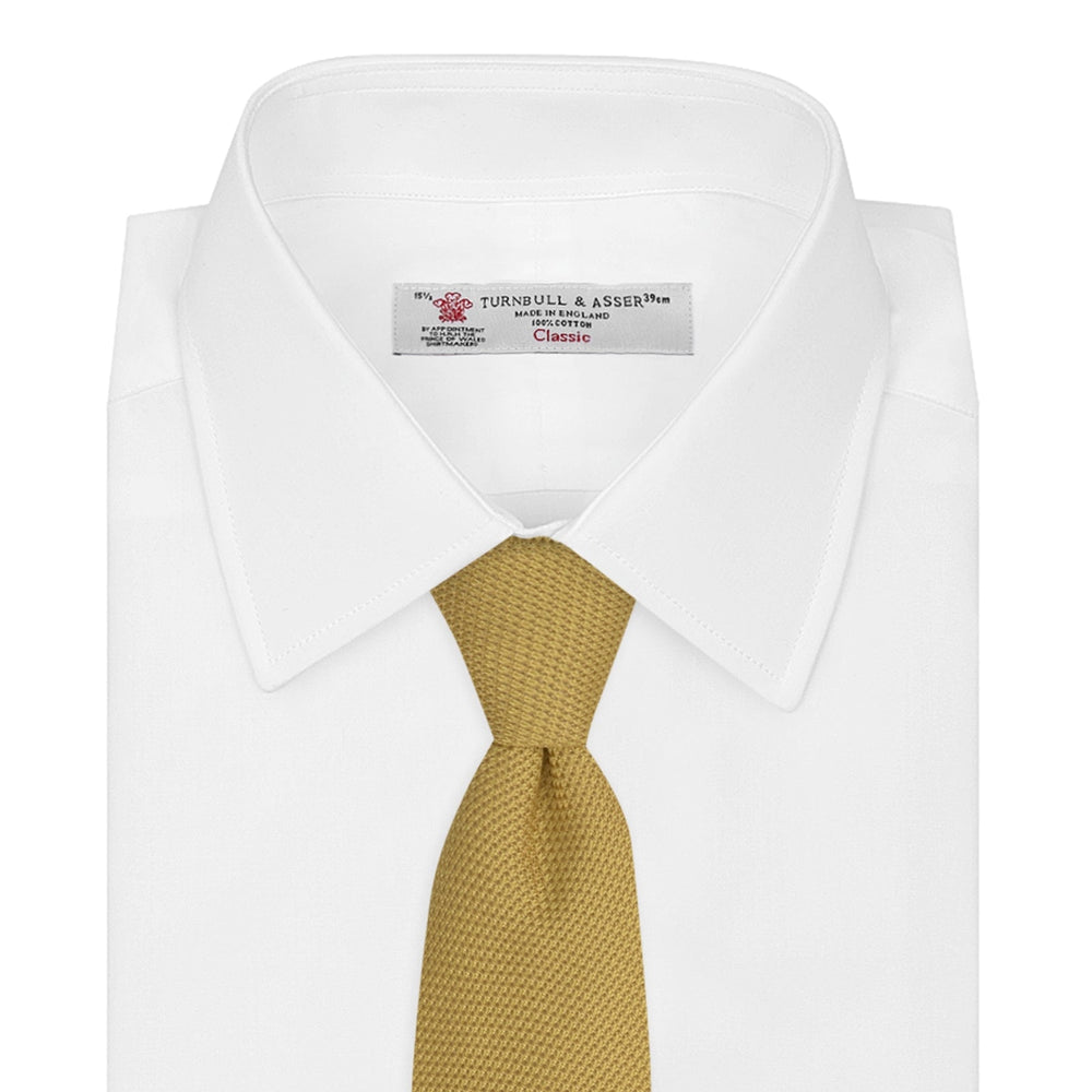 The Turnbull & Asser Gold Grenadine Silk Tie, recognized for its dimensional stability, is shown rolled up against a plain white background.
