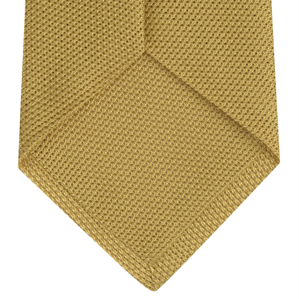 The Turnbull & Asser Gold Grenadine Silk Tie, recognized for its dimensional stability, is shown rolled up against a plain white background.