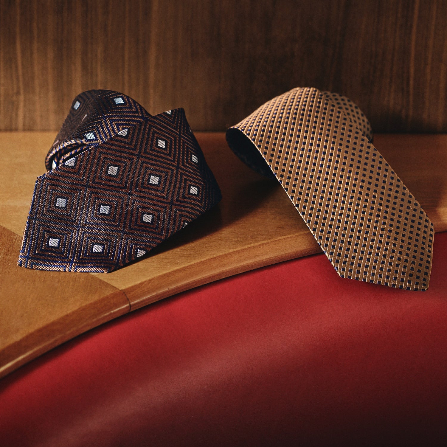 View 2 of product The Turnbull & Asser Tomorrow Never Dies Diamond Silk Tie, as seen on James Bond, features a gold and navy checkered pattern—an ideal gift for any Bond fan. Displayed rolled against a plain white background.