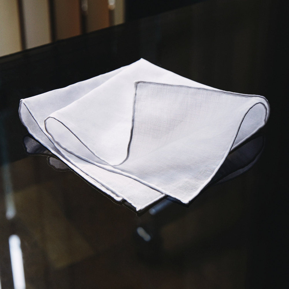 The James Bond Voile Pocket Square by Turnbull & Asser, in plain white with hand-rolled edges, is neatly folded and laid flat on a white background—a classic accessory for timeless style.