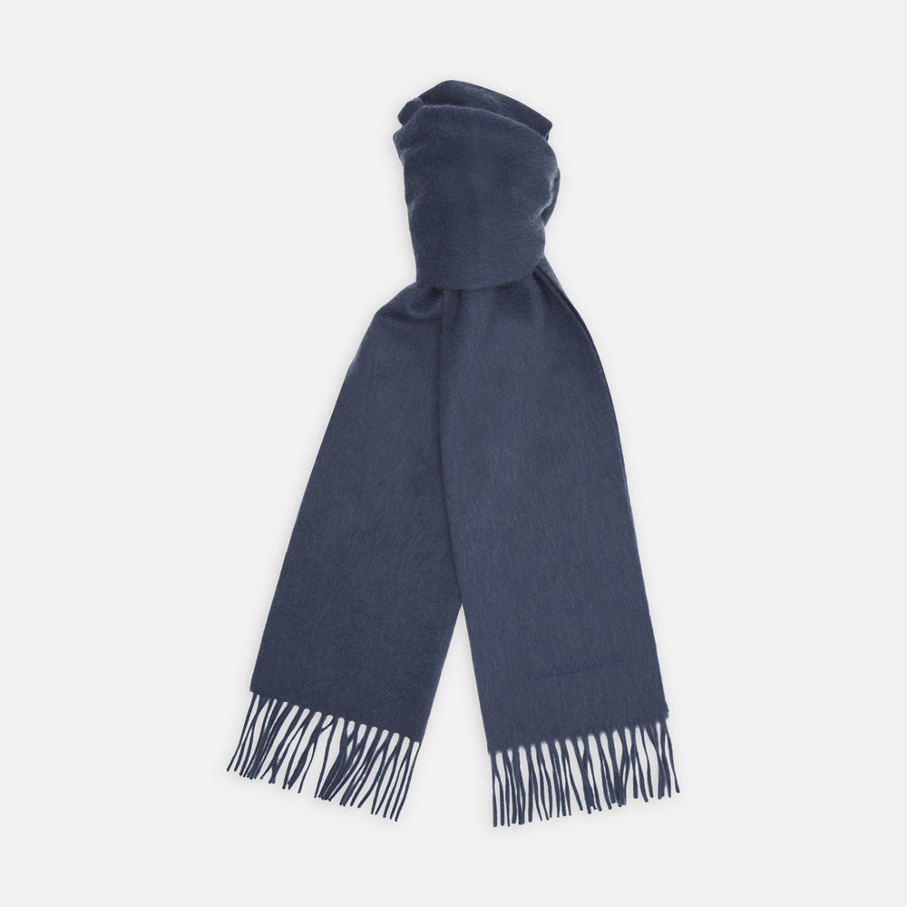 The Turnbull & Asser Slate Pure Cashmere Scarf is a luxurious navy blue accessory with fringed ends, neatly folded and showcased on a plain white background.