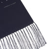 View 2 of product The Turnbull & Asser Navy and White Spotted Silk Scarf with Fringes, featuring small polka dots and grey fringe at both ends, is neatly folded and displayed on a plain white background.