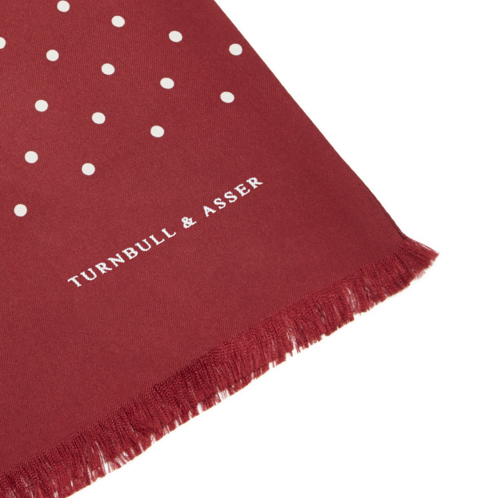 View 2 of product The Turnbull & Asser Burgundy and White Spotted Silk Scarf features small white dots, subtle fringed ends, and is neatly folded against a plain white background.
