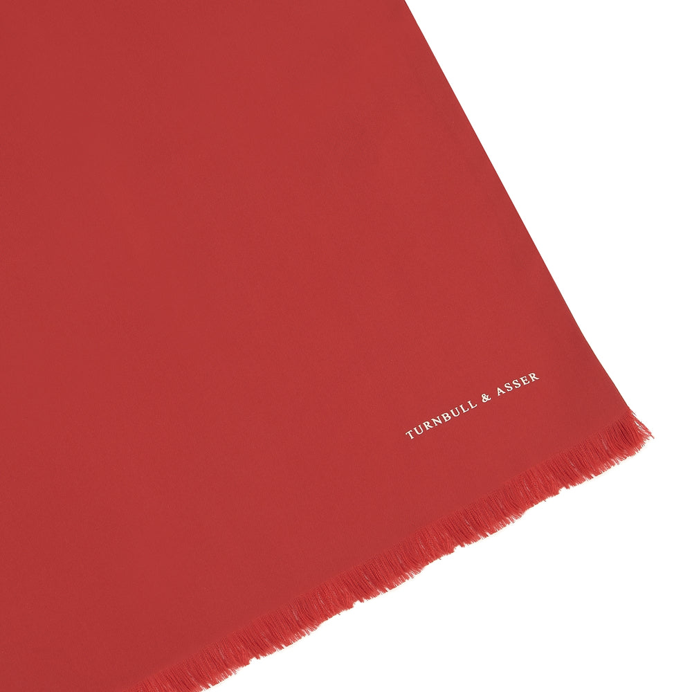 A Plain Red Silk Scarf by Turnbull & Asser is neatly folded and laid flat on a white background, featuring small white "Turnbull & Asser" text in one corner.
