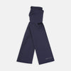 View 1 of product A Plain Navy Silk Scarf by Turnbull & Asser, neatly folded with both ends hanging down, is shown against a white background. One end displays subtle white branding, highlighting this elegant accessory.