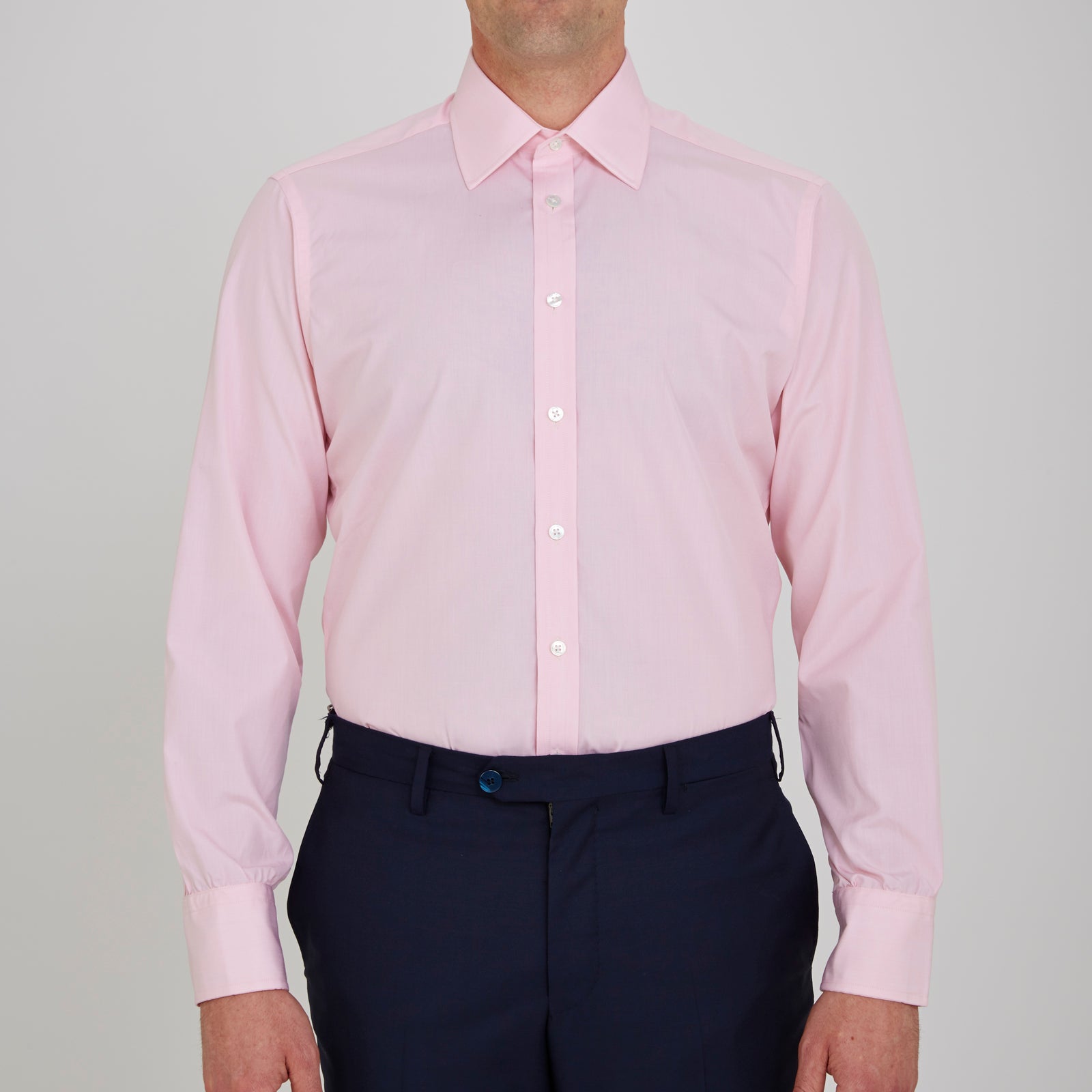 View 2 of product The Turnbull & Asser Pink End-on-End Shirt features a T&A collar, 3-button cuffs, and white buttons—a refined choice for any smart look—shown neatly folded against a plain white background.