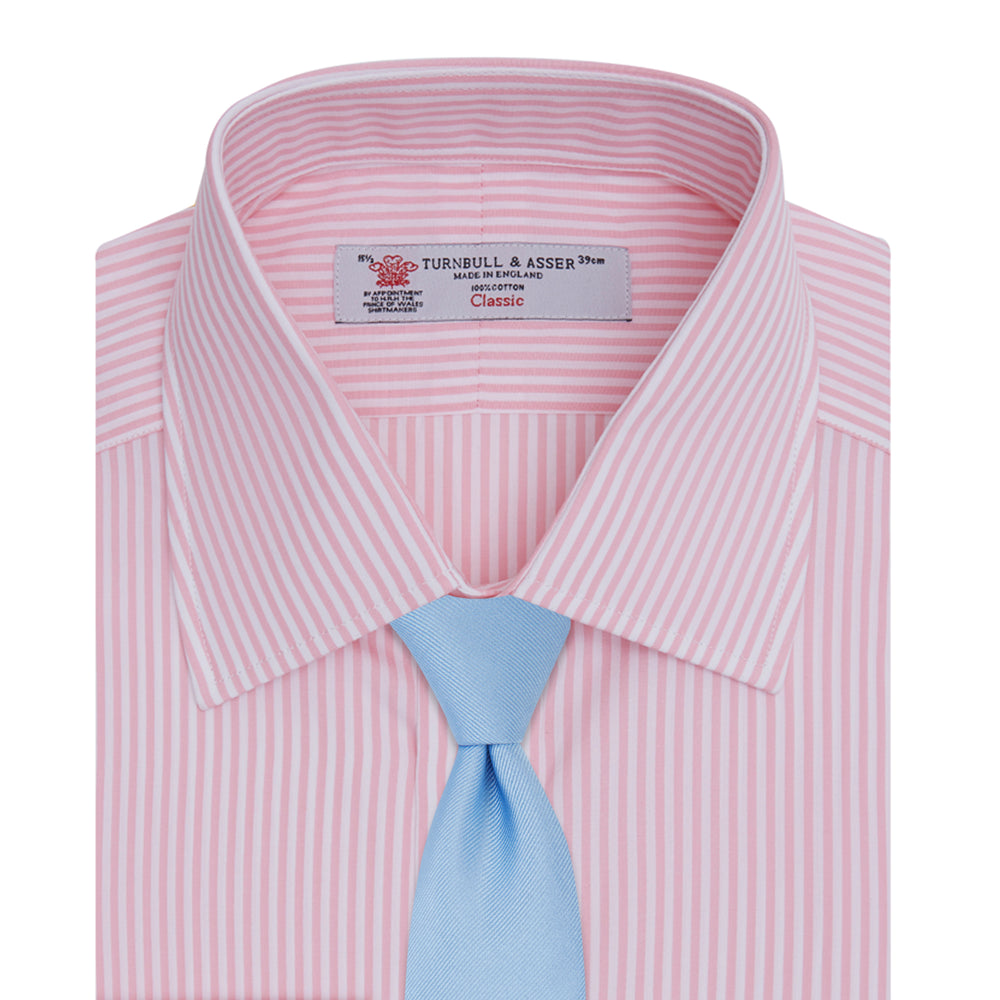 A neatly folded Turnbull & Asser blue shirt with a regent collar and 2-button cocktail cuffs, displayed against a plain white background.