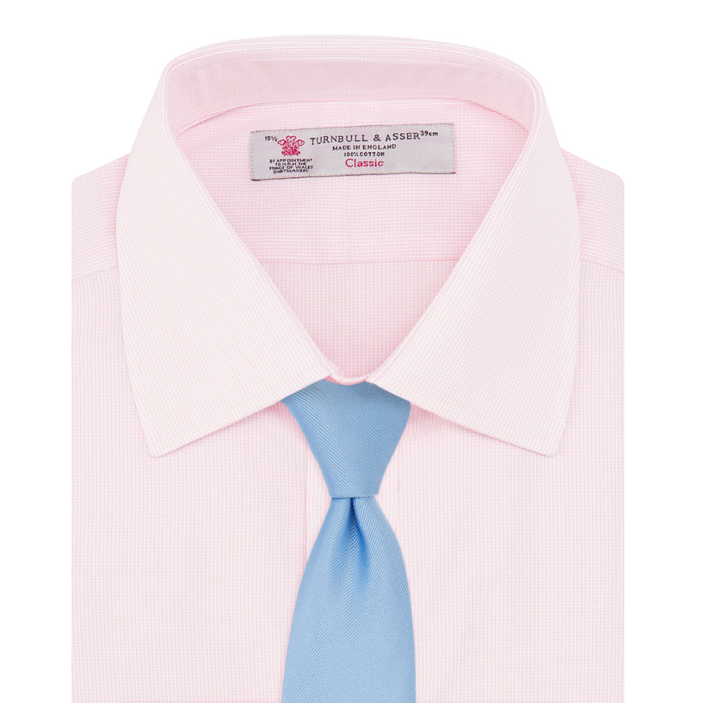 The Turnbull & Asser Pink Fine Check Shirt features a T&A collar, 3-button cuffs, and a subtle pink check design, made from fine cotton. Displayed neatly folded against a plain backdrop.